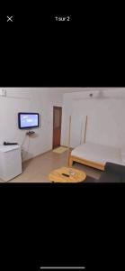 a room with a table and a tv in it at Apparemment studio in Cotonou