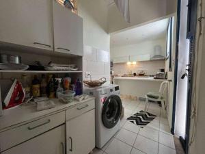 a kitchen with a washing machine in a kitchen at Casa Colonial 3 Suites na Urca - Rio de Janeiro, Vista Baía Guanabara e Vista Pão de Açucar in Rio de Janeiro