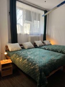 Dos camas sentadas en una habitación con ventana. en PRIVATE ROOMS - Tom Hostel, en Cracovia 47 fotos más