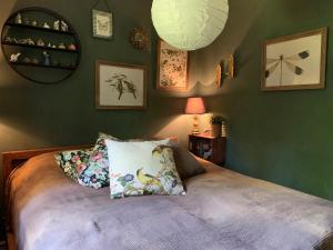 a bedroom with green walls and a bed with two pillows at Nice log house near lake and forest in Vittsjö in Vittsjö