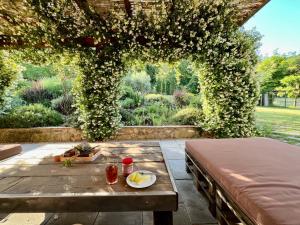 an outdoor patio with a table and an arch with flowers at LA PRUNETINA, Mugello Serene Country Residence near Florence in Florence