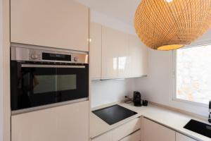 a kitchen with white cabinets and a black oven at Casa MuMa in Calpe
