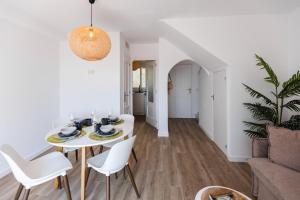 Una sala de estar blanca con una mesa y sillas. en Casa MuMa, en Calpe