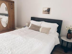 a bedroom with a large white bed with a mirror at Beautiful Private Guest House in Arcadia in Phoenix