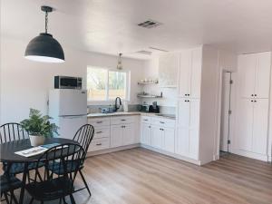 a kitchen with white cabinets and a table with chairs at Beautiful Private Guest House in Arcadia in Phoenix