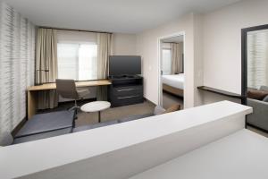 a hotel room with a desk and a tv at Residence Inn by Marriott Modesto North in Modesto +24 photos