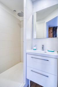 une salle de bain blanche avec un lavabo et un miroir dans l'établissement Studio Himalaya-Au coeur de la ville, à Palaiseau