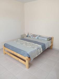 ein Holzbett mit einer blauen Decke auf dem Boden in der Unterkunft Santa Elena Casa de Campo in Federación + 12 Fotos