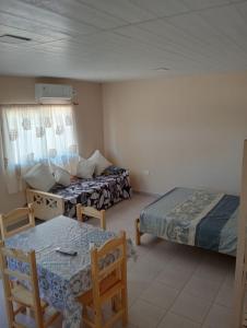 ein Zimmer mit zwei Betten und einem Tisch und Stühlen in der Unterkunft Santa Elena Casa de Campo in Federación