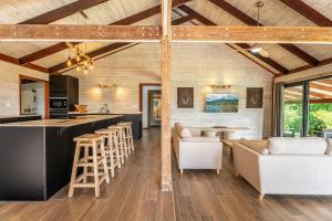 a kitchen and living room with a bar with stools at Villa Illary, paradise vert in Le Robert +30 photos