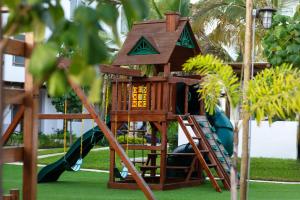a tree house with a ladder and a slide at Departamento a 5 min de la playa, Cerritos in Mazatlán
