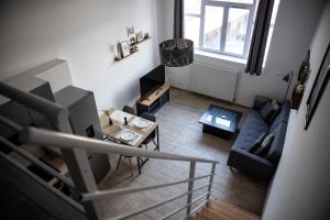 ein Wohnzimmer mit Sofa und Tisch in der Unterkunft Le Passementier, T2 duplex grand volume parking souterrain wifi Netflix in Saint Etienne