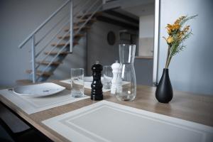 einen Tisch mit einer Vase aus Blumen und Gläsern darauf in der Unterkunft Le Passementier, T2 duplex grand volume parking souterrain wifi Netflix in Saint Etienne + 22 Fotos