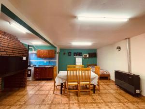 Un comedor con mesa y sillas y una cocina. en Hospedaje don bolke, en Gobernador Gregores