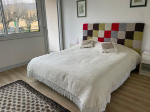 ein Schlafzimmer mit einem großen Bett mit einem karierten Kopfteil in der Unterkunft L'Appartement d'Hélène in Sarlat-la-Canéda