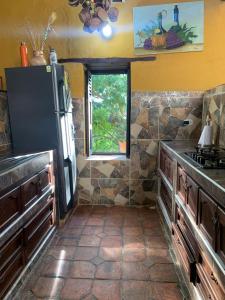 a kitchen with a black refrigerator and a window at Posada Altagracia San Gil in San Gil