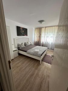 a bedroom with a large bed and a wooden floor at Karolina Apartment in Alba Iulia