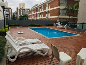 una terrazza con sedie e una piscina di Apto a 2 min a Pé da Praia - Edificio Monte Carmel a Guarujá