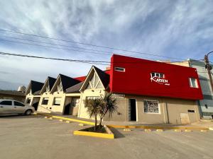 a red building in front of a row of houses at Kaizen Apart Departamento 3 in Caleta Olivia