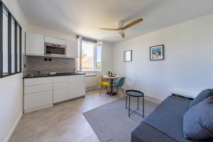 a living room with a blue couch and a kitchen at Le repaire de Barbizon in Barbizon