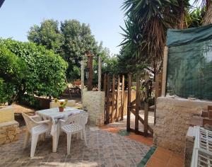 a patio with a table and chairs and a fence at Villa Migliore in Lampedusa