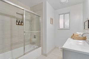 a white bathroom with a shower and a sink at Our West Nest, Charming 3 BR-5 Bed - Backyard - Olde Town Arvada in Arvada +26 photos