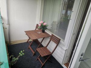a table and chairs on a porch with a vase of flowers at Apartment 137 in Ikaalinen Spa-Hotel, 1st floor in Ikaalinen