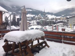 an umbrella sitting on a table covered in snow at Appartamento il Nido in Moena