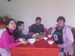 un grupo de personas sentadas en una mesa comiendo comida en Cuc Phuong Bungalow, en Phủ Nho Quan