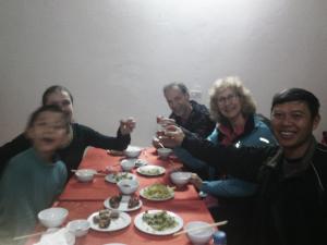 a group of people sitting around a table with food at Cuc Phuong Bungalow in Phủ Nho Quan
