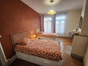 a bedroom with two beds and a window at L 'Échappée Cambrésienne in Cambrai