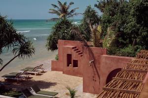 阿杭格默The Find Hotel的海滩上的建筑,带椅子和大海