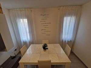 a dining room table with a writing board on the wall at Suite Piazzetta Vigo in Chioggia +18 photos