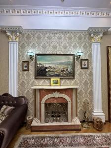 a living room with a fireplace with a painting on the wall at Sea Premium LUXURY APARTMENT 5 STARS in Baku