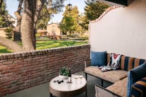 a patio with a table and chairs and a brick wall at Paso Robles Inn in Paso Robles
