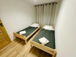 deux lits jumeaux dans une chambre avec dans l'établissement Apartament Bałandy - 10, à Oświęcim