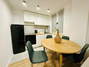une cuisine avec une table, des chaises et un vase. dans l'établissement Apartament Bałandy - 10, à Oświęcim 12 autres photos