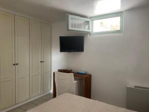 una camera da letto con un letto e una televisione a parete di Waterfront Luxurious Villa - Kea Island a Melissaki