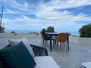 eine Terrasse mit einem Tisch und Stühlen auf dem Dach in der Unterkunft Casa da Madrinha in Fenais da Ajuda