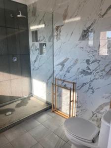 a bathroom with a toilet and a glass shower at Soltroia Dunas House in Troia +27 photos