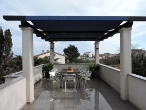 a black pergola on a balcony with a table and chairs at Apartment Silva free wifi free parking in Ližnjan