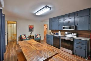 a kitchen with blue cabinets and a wooden table at The Hala Lodge and Campground -Riverfront Class 5 -2bed 2bath on Nantahala River in Bryson City