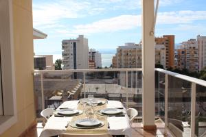 une table sur un balcon avec vue sur une ville dans l'établissement Apto en Cullera con terraza, piscina, parking y wifi gratis, à Cullera