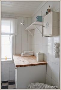 cocina con encimera y electrodomésticos blancos en Nostalgiske Halsebøstua, en Harstad