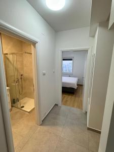 a bathroom with a shower and a bed in a room at Banja Luka Comfort - Wifi & Parking in Banja Luka