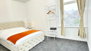 a white bedroom with a large bed and a window at 6-Sleeper 3BR Garden Beach - FREE parking in Portsmouth