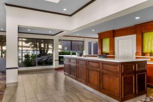 a large kitchen with wooden cabinets and white counter tops at ACP Hotel Houston Westchase, MOD Collection by Sonesta in Houston