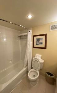a bathroom with a toilet and a tub and a sink at ACP Hotel Houston Westchase, MOD Collection by Sonesta in Houston