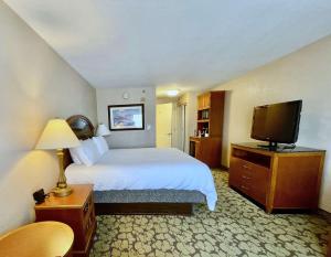 a hotel room with a bed and a flat screen tv at ACP Hotel Houston Westchase, MOD Collection by Sonesta in Houston +47 photos