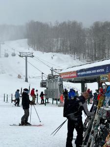 Stylish Forest Lodge with Large Hot Tub, Firepit and Fireplace minutes to Gore Mountain في North Creek: مجموعة من الناس على الزحاف في مصعد التزلج